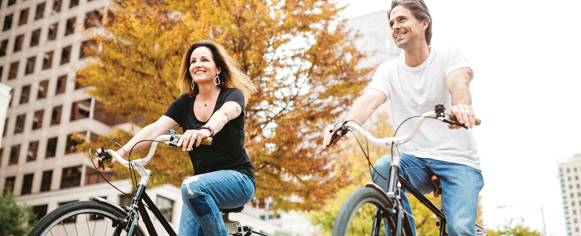 A smiling man and woman riding bikes through Austin, Texas. 
