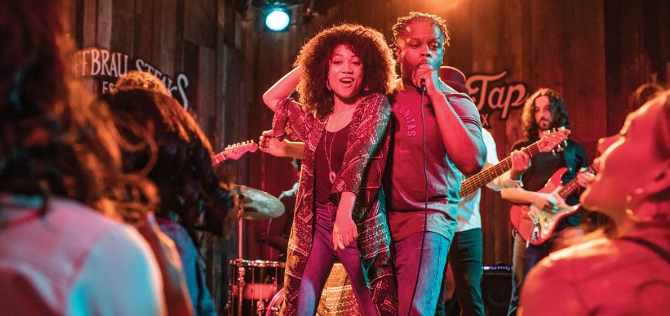 A man and woman perform on stage at a rock concert in Austin, Texas.