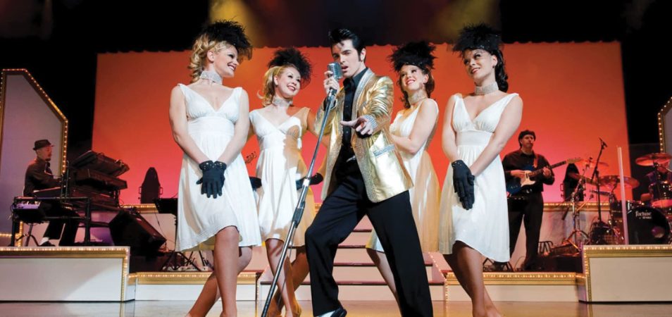 An Elvis Presley impersonator and female performers on stage at Dick Clark's American Bandstand Theater.