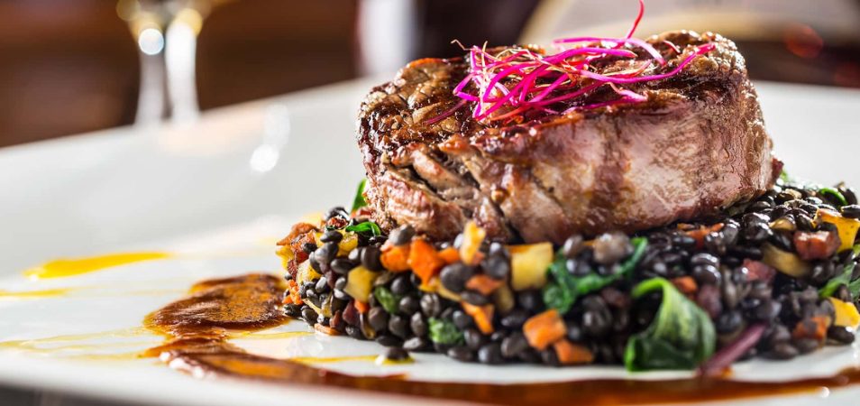 A beefsteak sitting atop black beans and vegetables at Level 2 Steakhouse in Branson, Missouri.