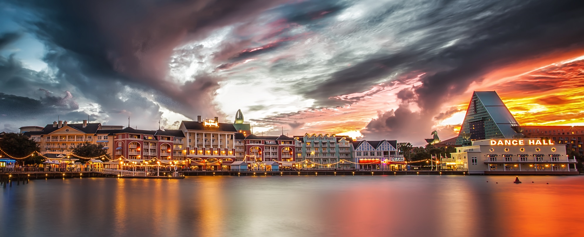 Disney's Boardwalk, a waterfront resort and entertainment, dining, and shopping area in Orlando, Florida lit up at sunset.