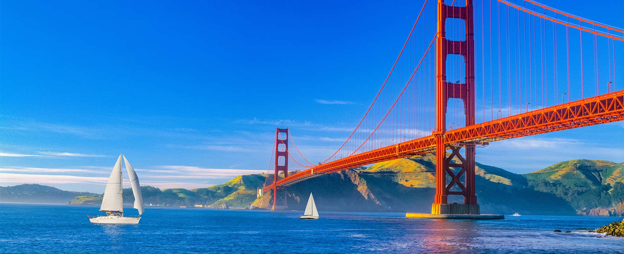 Sailboats on the water in front of the Golden Gate Bridge in San Francisco, California.