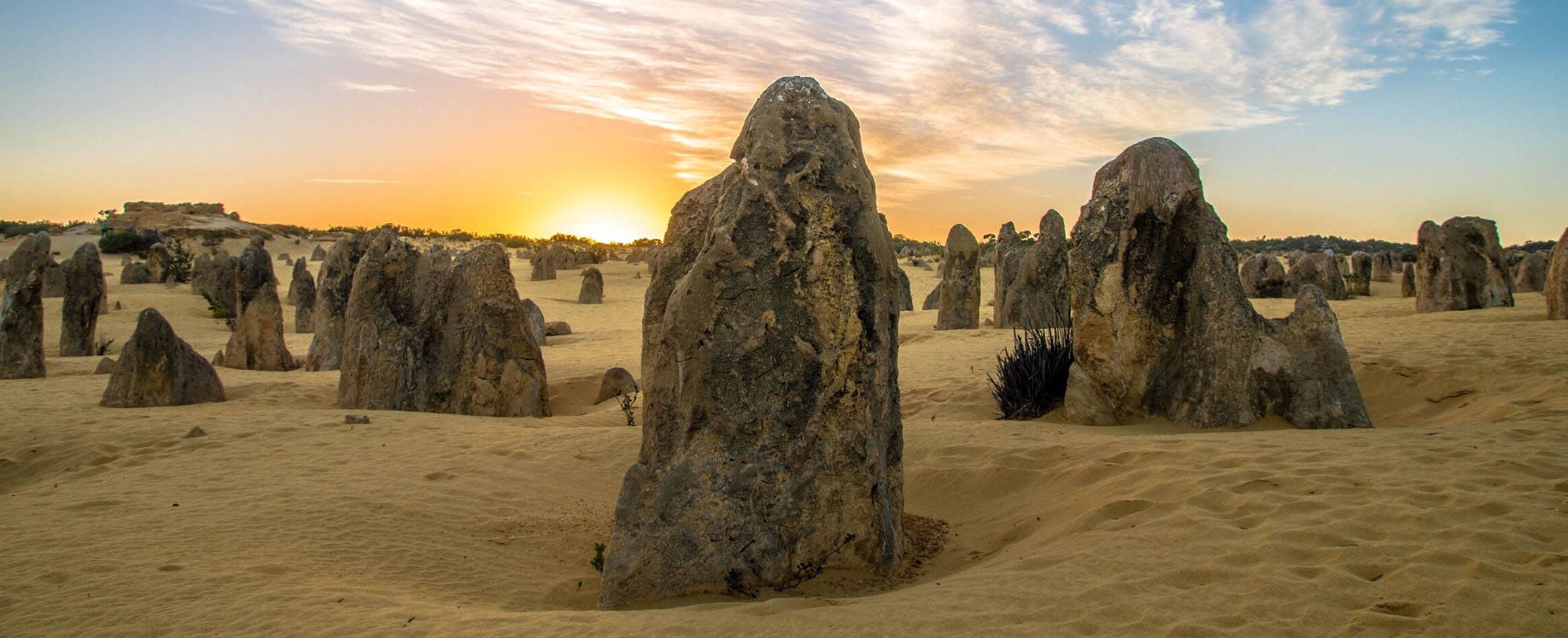 The sun sets on large rock formations in the sand at Pinnacles National Park in California.