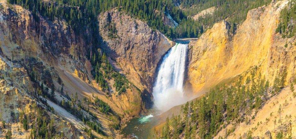 A bird's-eye-view of mountains and a waterfall at Yellowstone National Park.