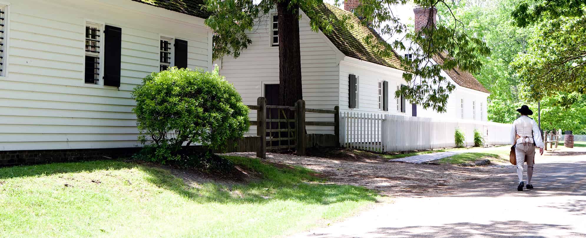 Historical inturpreter walking down a cobble stone street in colonial Williamsburg in Williamsburg, Virginia