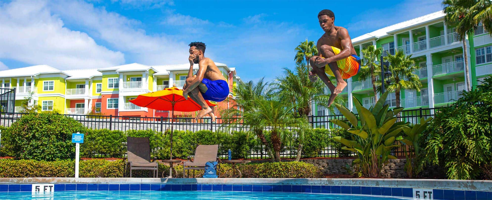 Two young men cannonballing into a Club Wyndham resort pool for an episode of Vacations Unpacked - Travel Smarter: Flex Stays. 