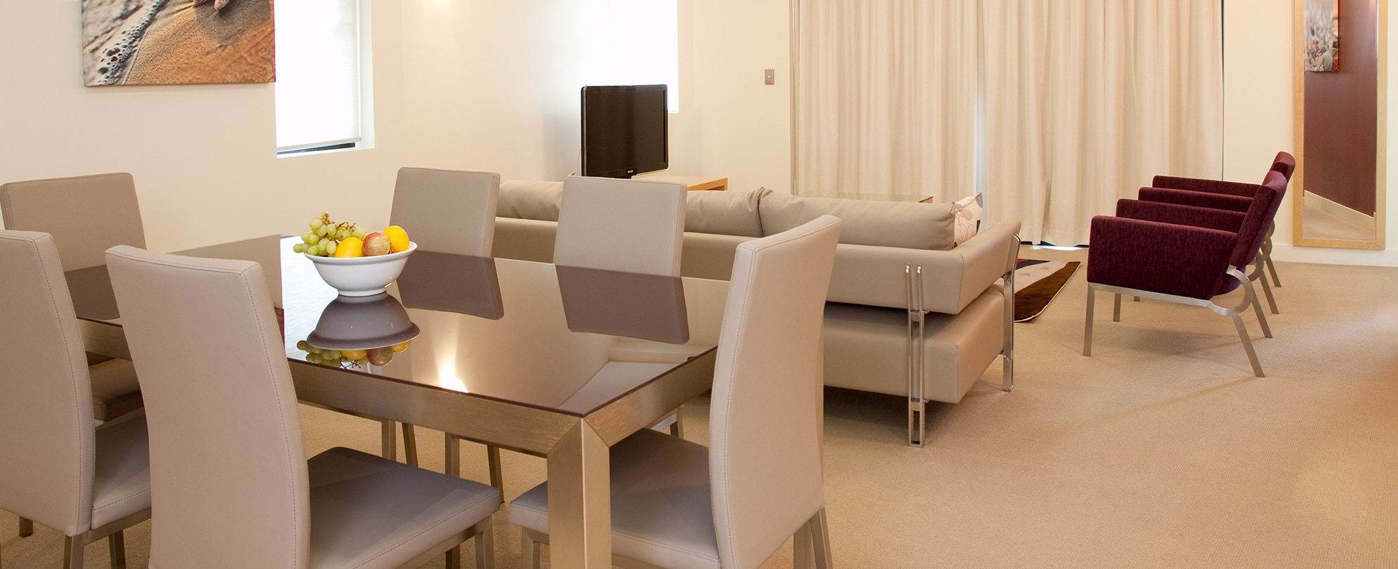 The living and dining area of a 2-bedroom deluxe suite at Club Wyndham Coffs Harbor.