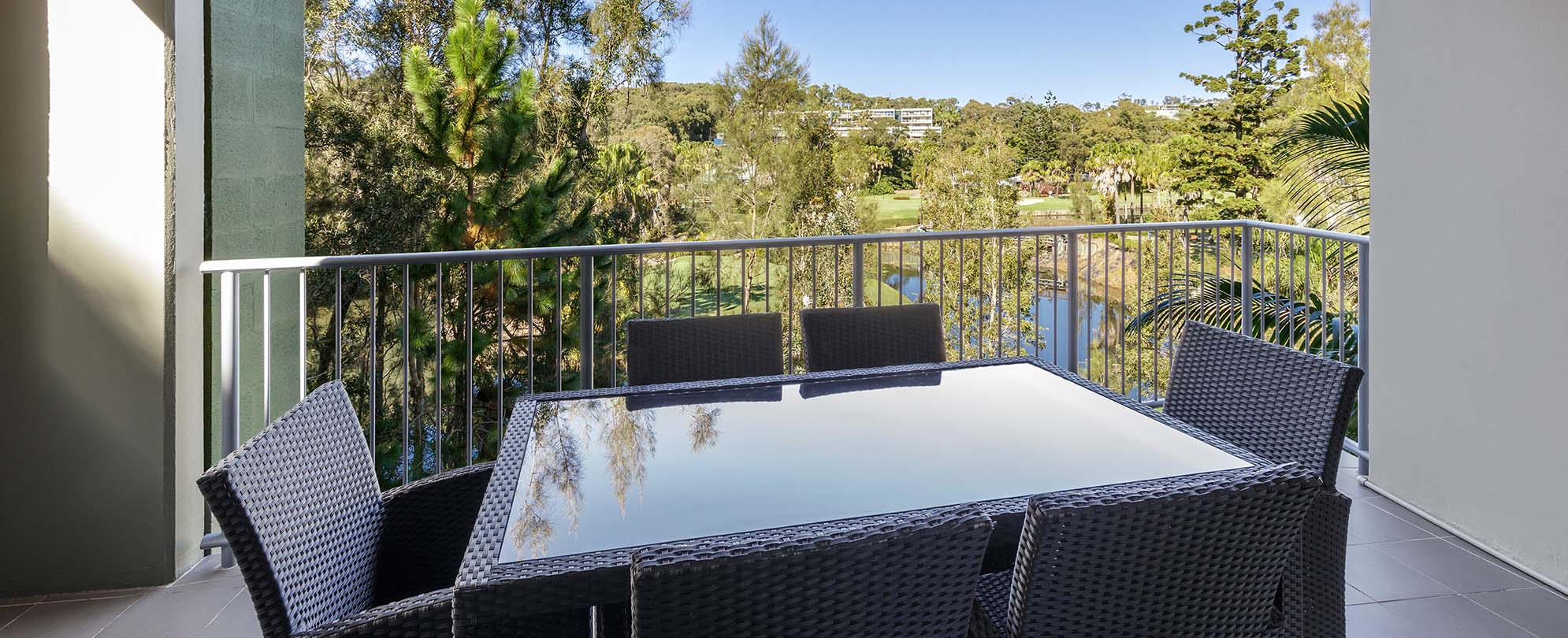 A table with six chairs out on the balcony of a 2-bedroom grand suite at Club Wyndham Coffs Harbor.