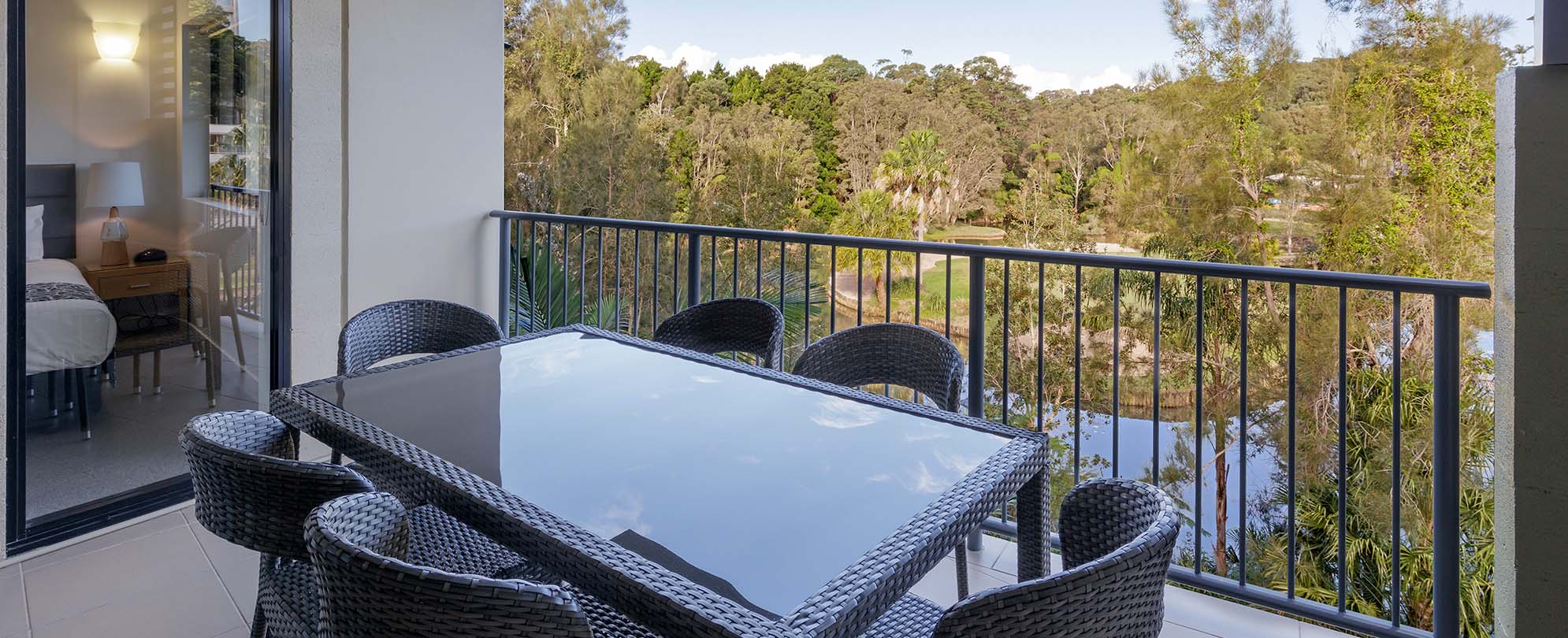 A table with six chairs on the balcony of a 2-bedroom suite at Club Wyndham Coffs Harbor.