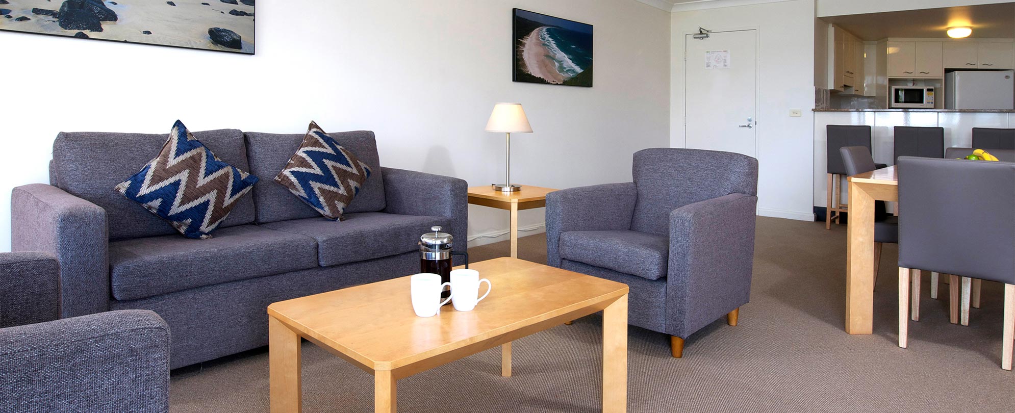 Couch, chairs, and coffee table in the standard living space of a Club Wyndham Port Macquarie suite.