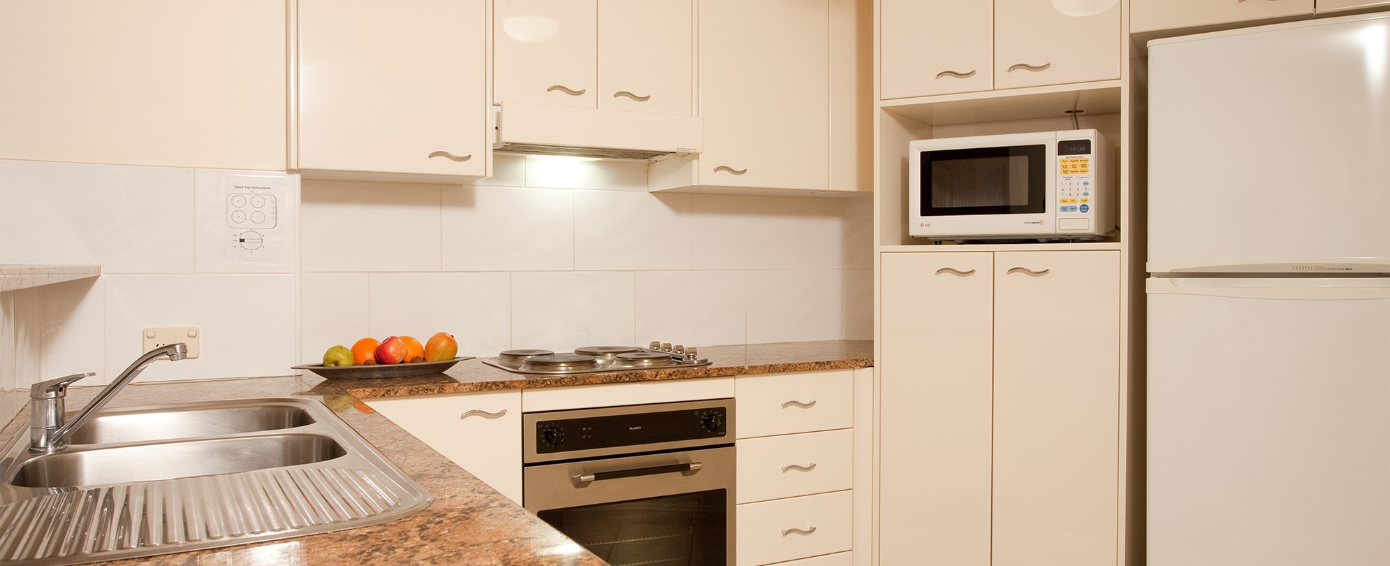 Kitchen with cabinets, refrigerator, stove, sink, and microwave in a Club Wyndham Port Macquarie suite.