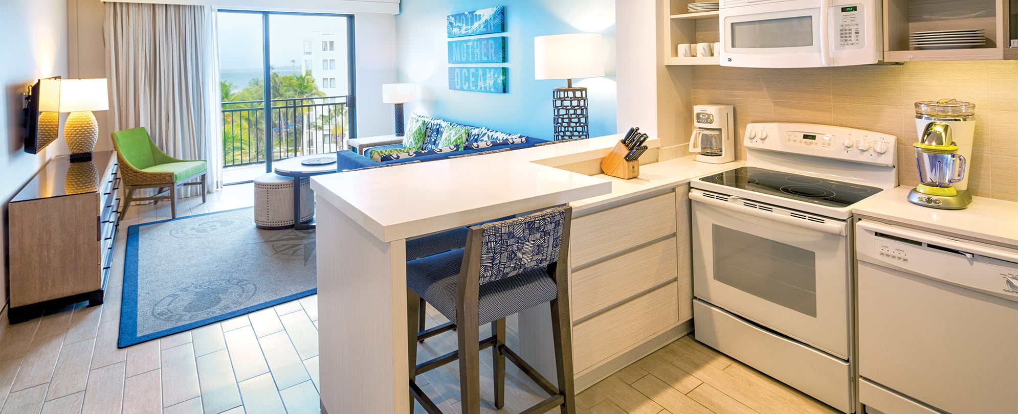 Kitchen and living room in a suite that overlooks the ocean at Margaritaville Vacation Club by Wyndham - Rio Mar.