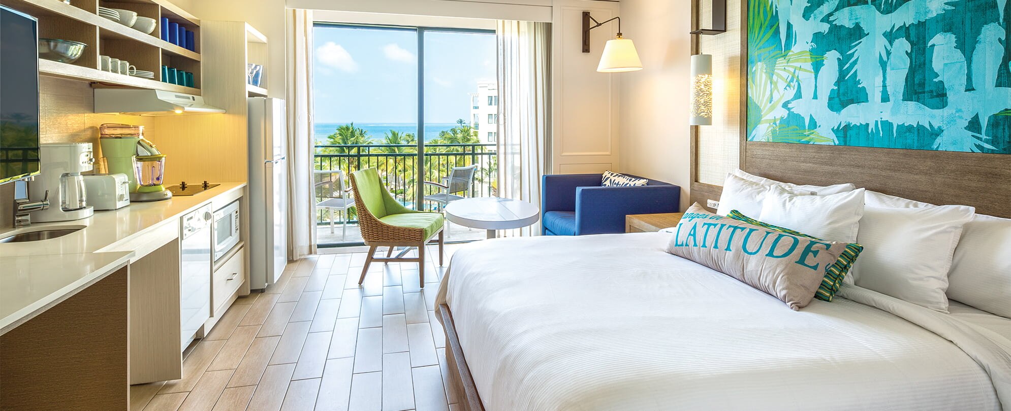 Kitchenette, couch, and bed in a studio suite with an ocean view at Margaritaville Vacation Club by Wyndham - Rio Mar.