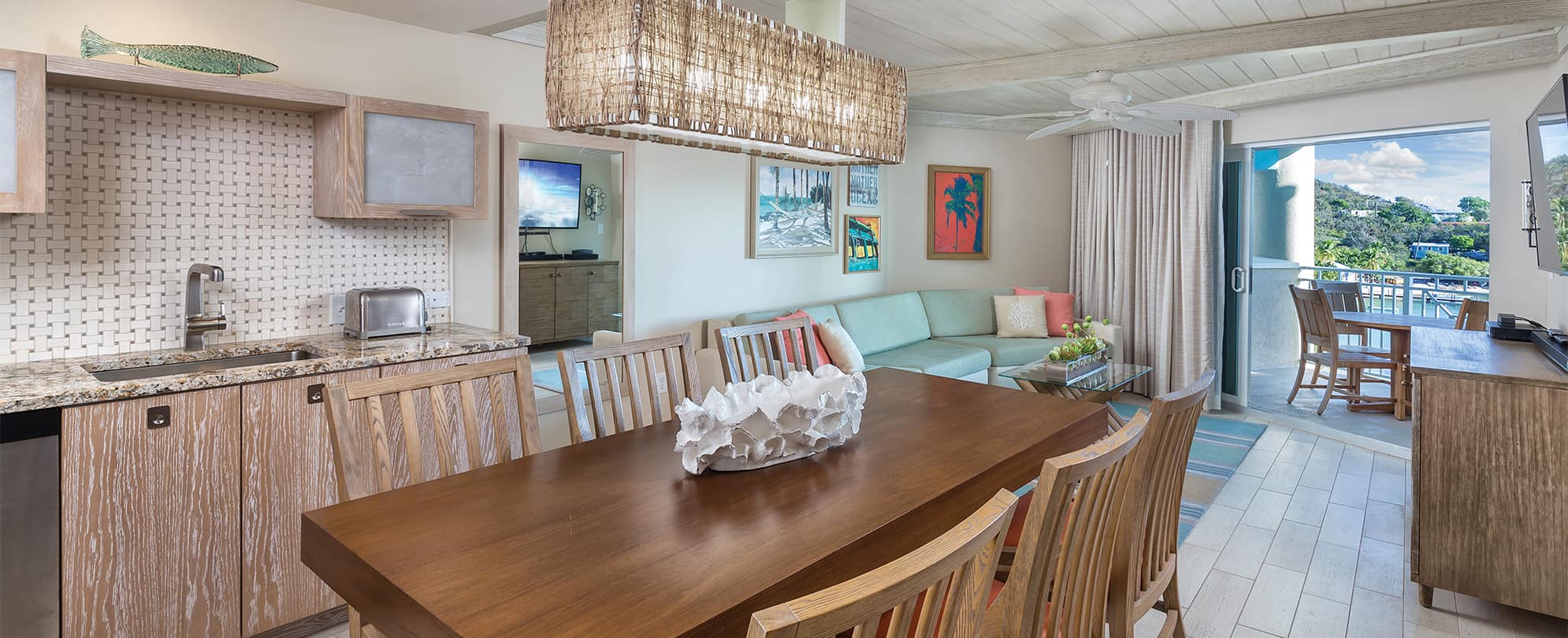 Dining room table, living room, and balcony of a Presidential Reserve suite at Margaritaville Vacation Club resort in St. Thomas.