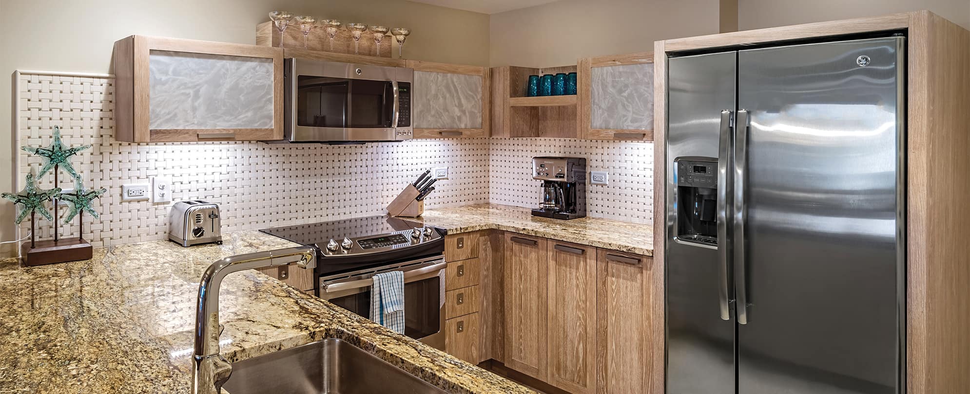 Refrigerator, sink, and stove in a Presidential Reserve suite kitchen at Margaritaville Vacation Club by Wyndham - St. Thomas.