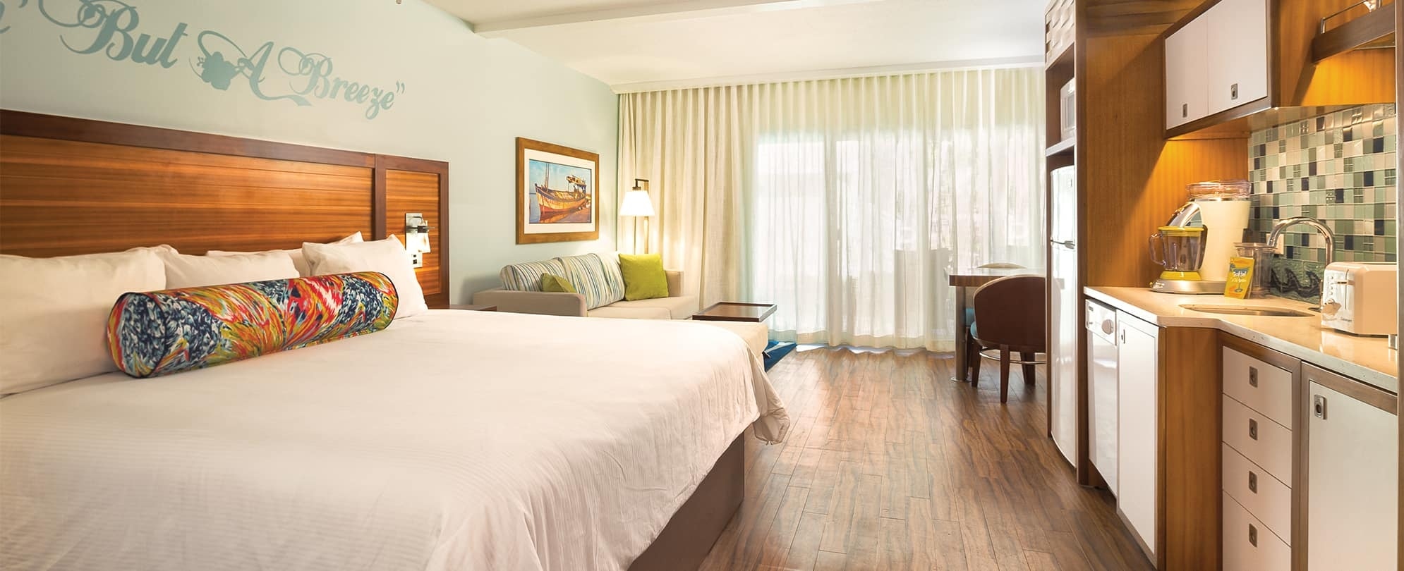Bed, kitchenette, and couch of a studio suite at Margaritaville Vacation Club by Wyndham - St. Thomas.