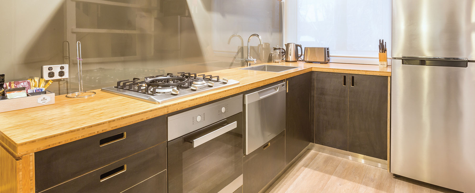 A kitchen with stainless steel appliances and wood countertops inside a 1-bedroom deluxe suite at Club Wyndham Dinner Plain Mt. Hotham resort. 