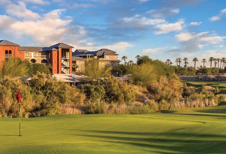 The green of a golf course, with Club Wyndham and WorldMark Indio timeshare resort in the distance.