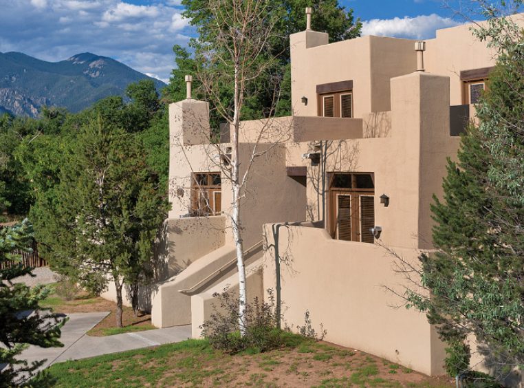 The exterior of Club Wyndham Taos, a timeshare resort in Taos, New Mexico, surrounded by trees and mountains.