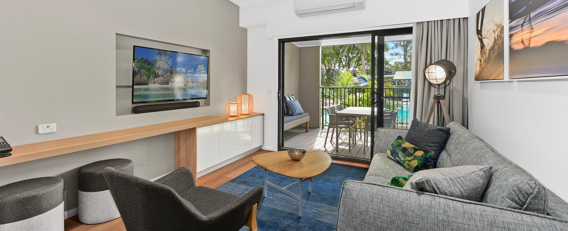 The living space with a sliding glass door leading to a patio in a Club Wyndham Flynns Beach deluxe suite.