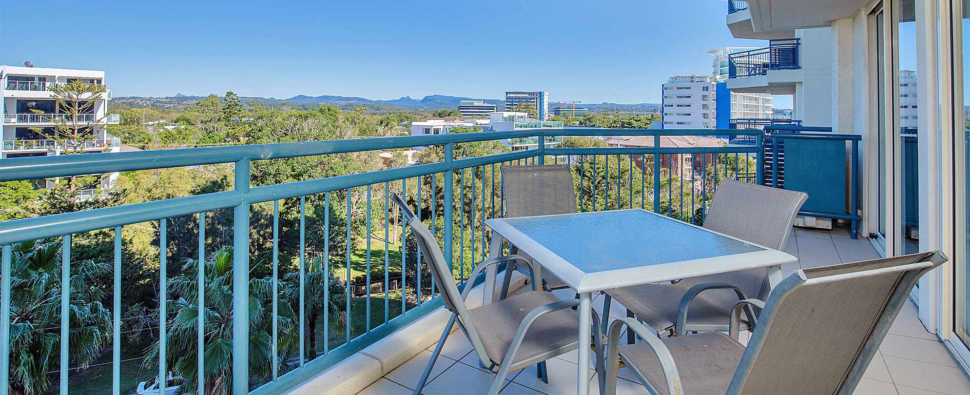 A balcony with a table and 4 chairs of a  Club Wyndham Kirra Beach handicap accessible suite.