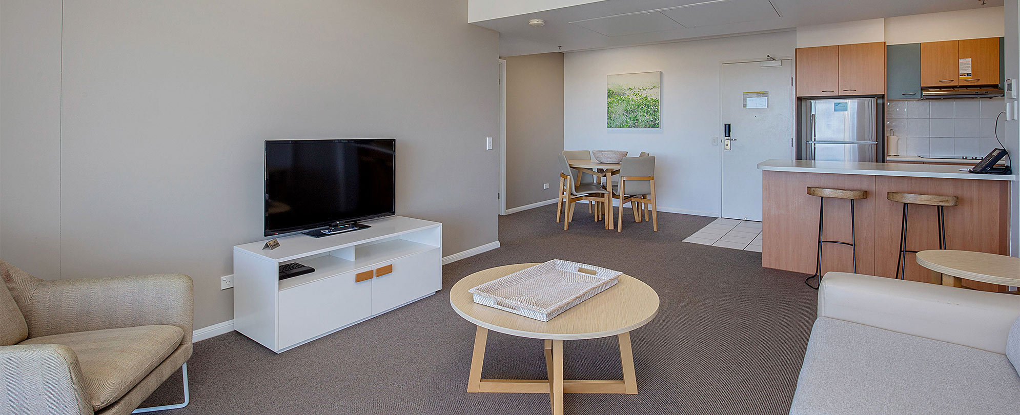 The living area, kitchen, and dining table in a Club Wyndham Kirra Beach standard suite.