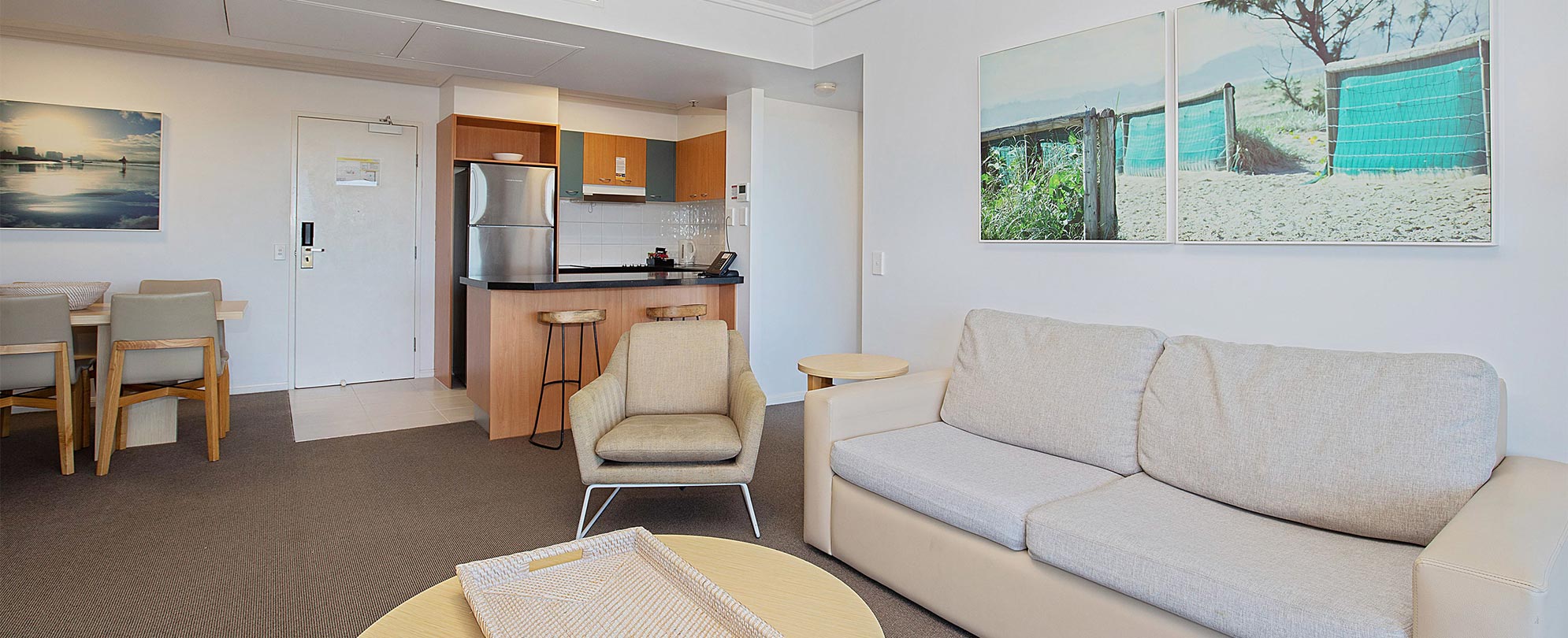 The living area, kitchen, and dining table in a Club Wyndham Kirra Beach standard suite.
