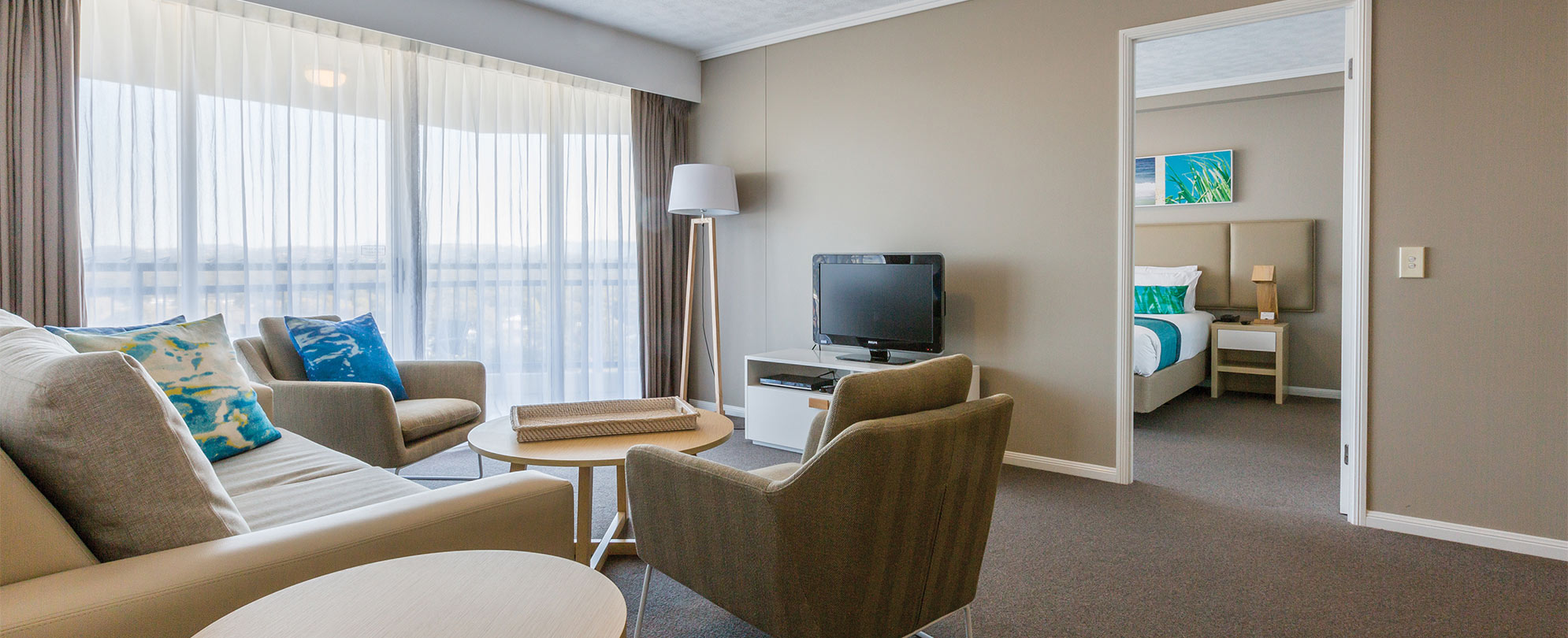 The living area of a Club Wyndham Kirra Beach standard suite with a doorway leading to a bedroom.