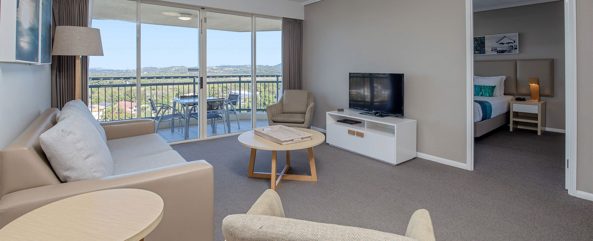 The living area of a Club Wyndham Kirra Beach standard suite with a doorway leading to a bedroom.