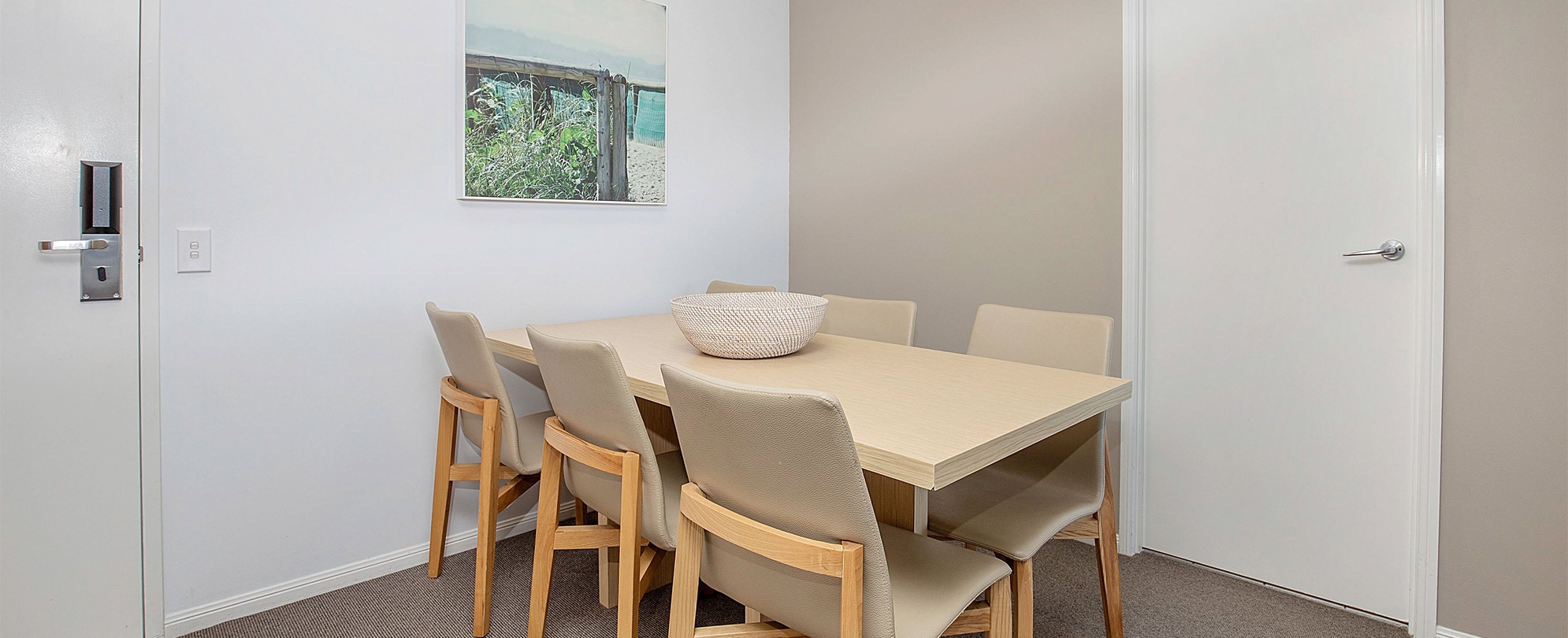 The dining table with 6 chairs in a Club Wyndham Kirra Beach standard suite.