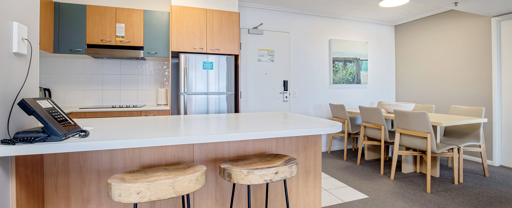 The kitchen and dining table of a Club Wyndham Kirra Beach standard suite.