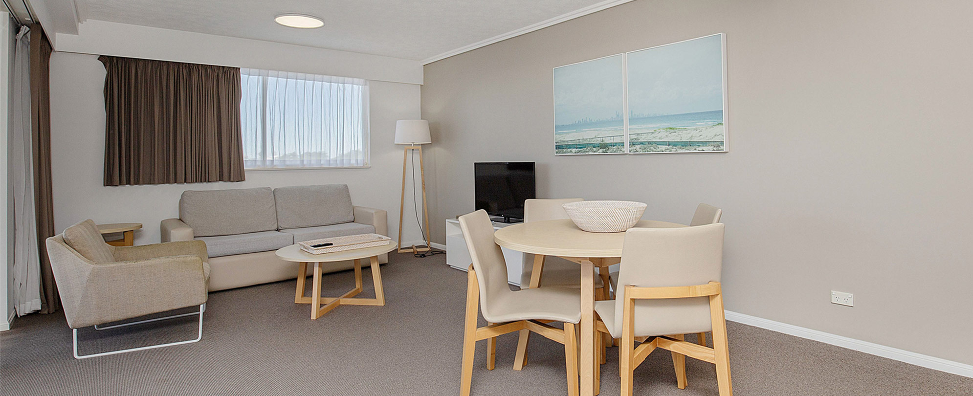 The living area and dining table with 4 chairs in a Club Wyndham Kirra Beach standard suite.