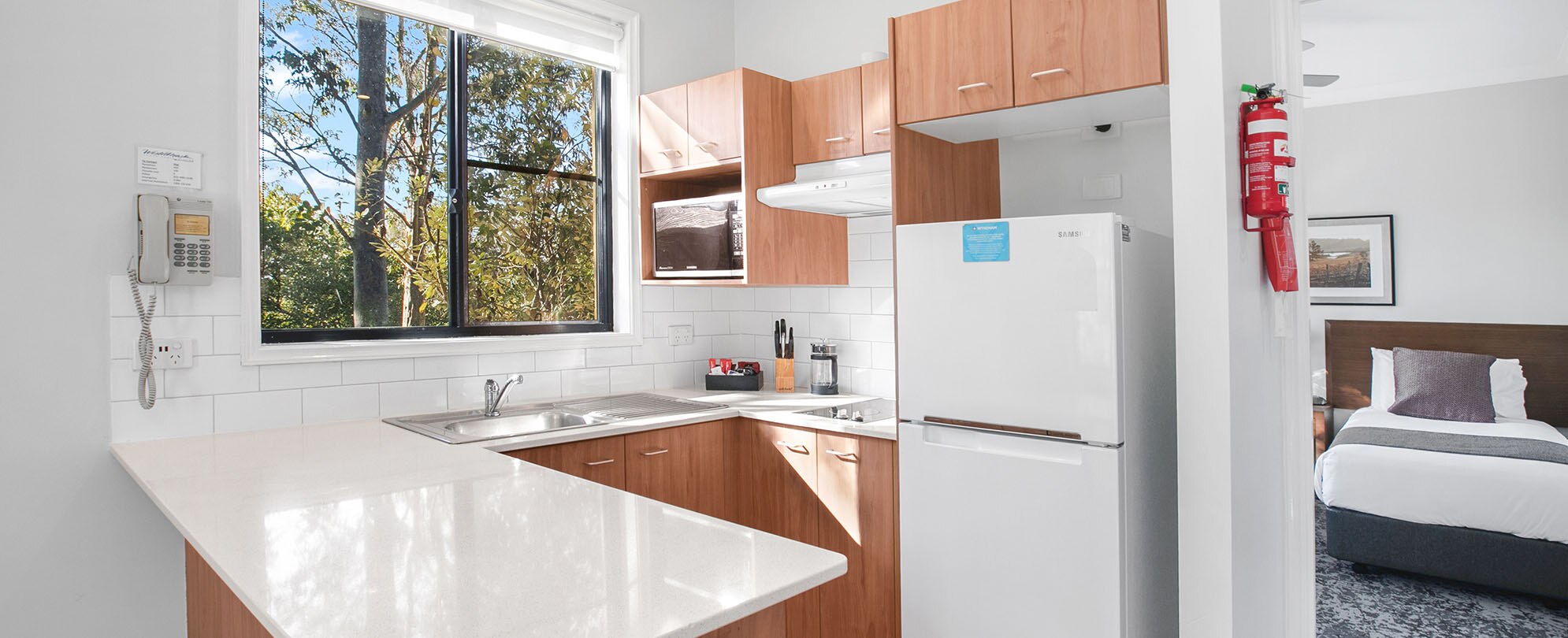 The full kitchen of a Club Wyndham Pokolbin Hill 2-bedroom suite, with a doorway leading to a bedroom.
