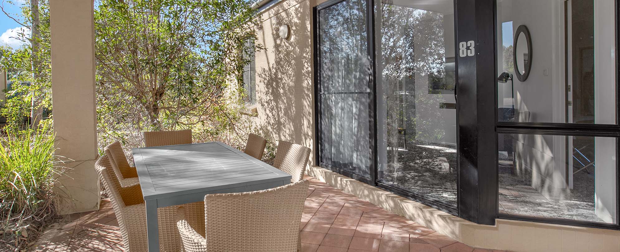 A glass sliding door leading to a patio with a table at a Club Wyndham Pokolbin Hill 2-bedroom suite.