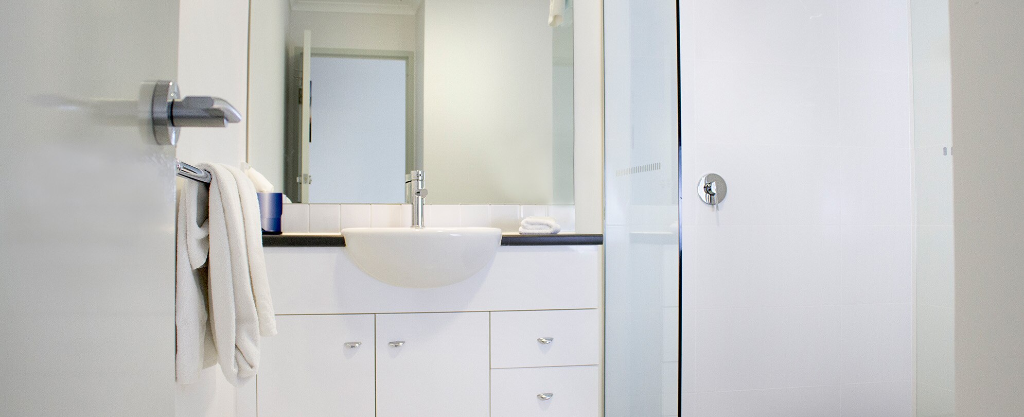The bathroom sink and walk-in shower in a 1-bedroom deluxe suite at Club Wyndham Shoal Bay.