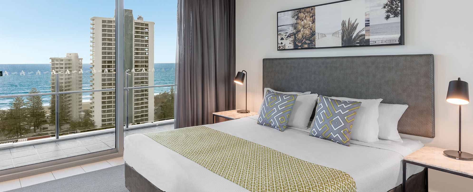 The bedroom and ocean view of a 1-bedroom suite at Club Wyndham Surfers Paradise.