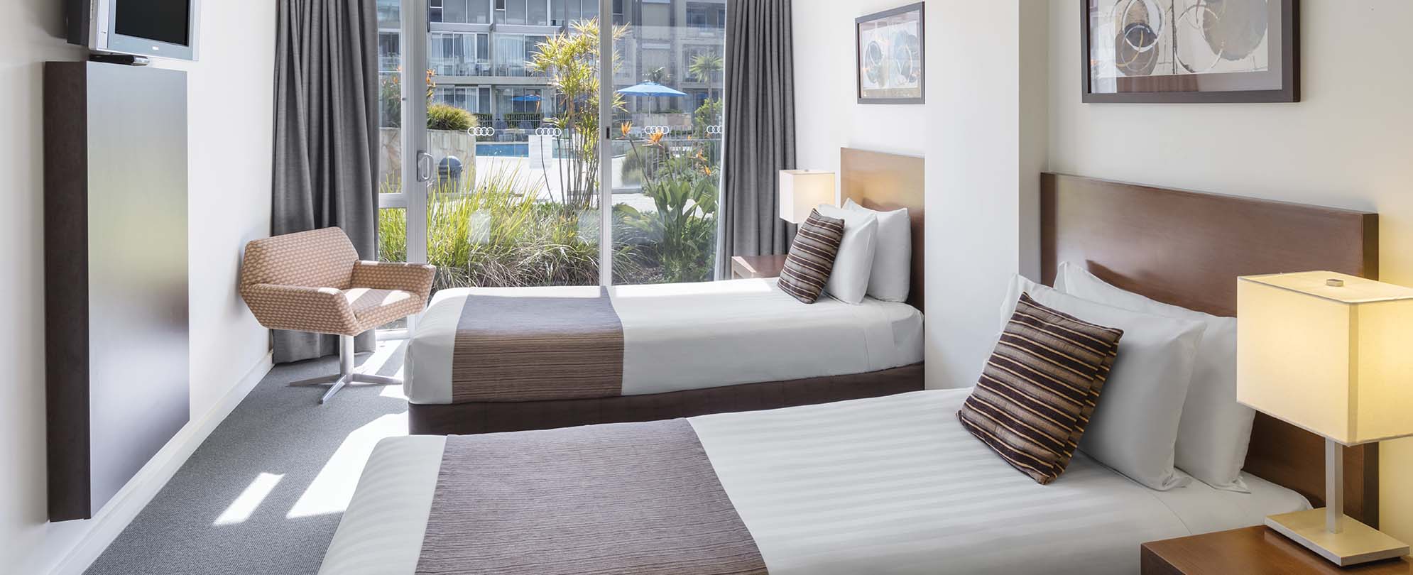 A bedroom, with two twin-sized beds, inside one of the suites at Club Wyndham Torquay. 