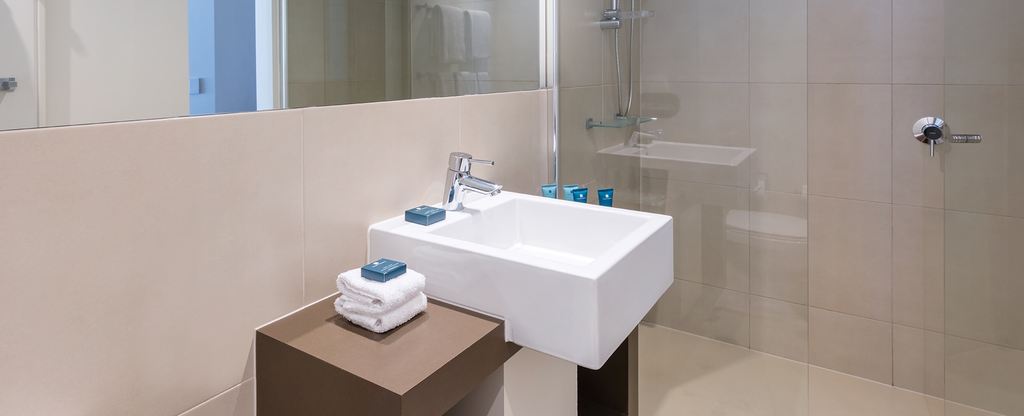 A modern sink, and walk-in shower, inside one of the suites at Club Wyndham Torquay.  