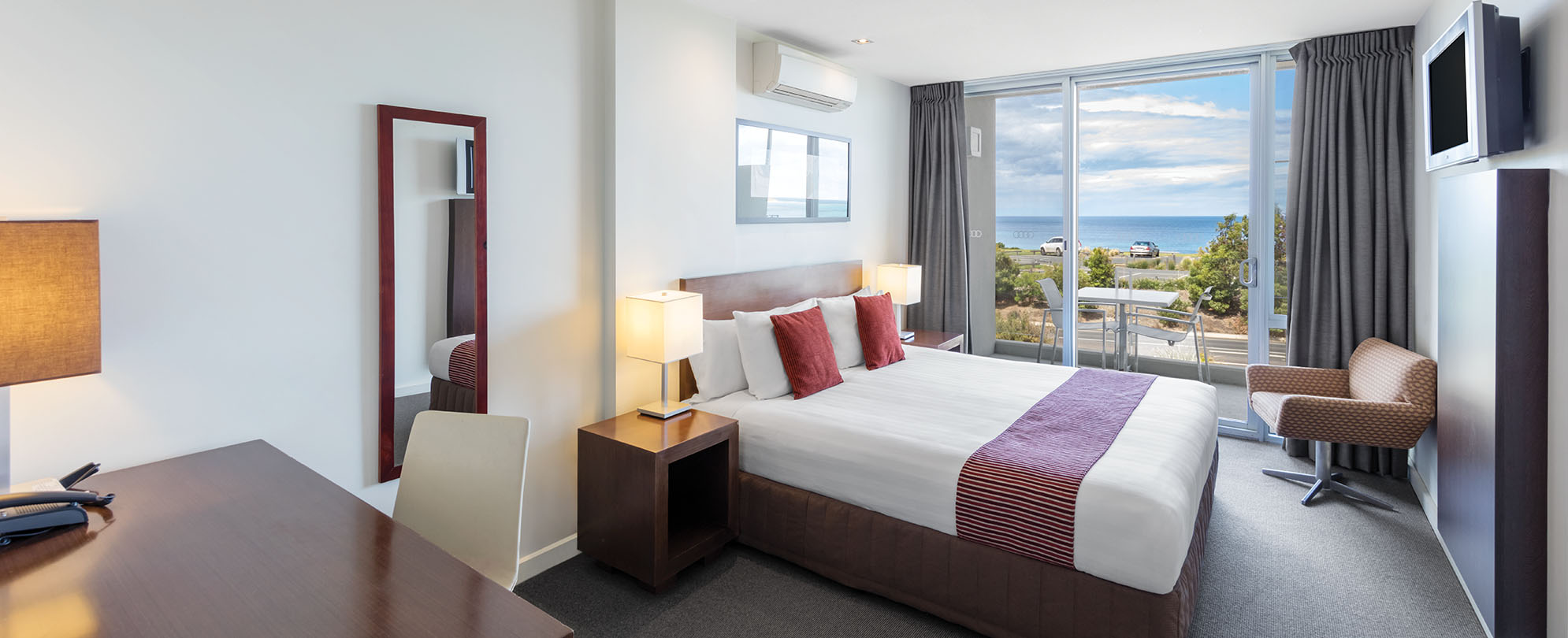 The bedroom inside a studio suite, with an ocean view at Club Wyndham Torquay.  
