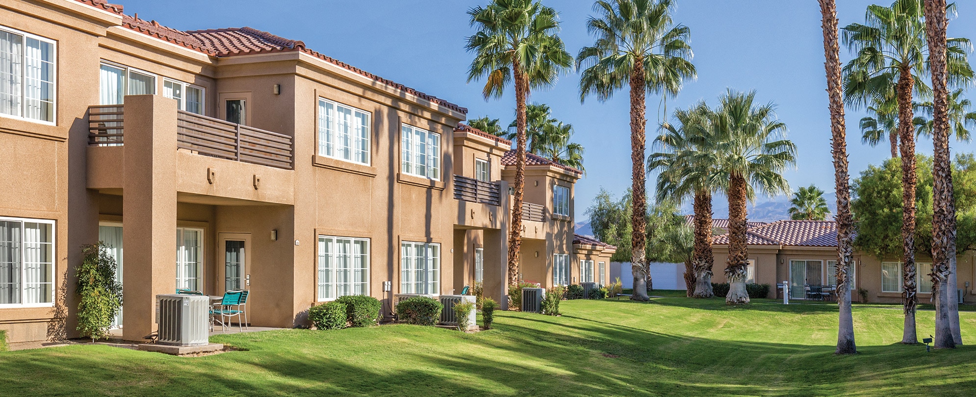 Palm trees surround the exterior of WorldMark Cathedral City, a timeshare resort in California.