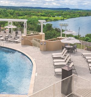 A pool surrounded by chairs overlooking a large body of water at WorldMark Marble Falls.