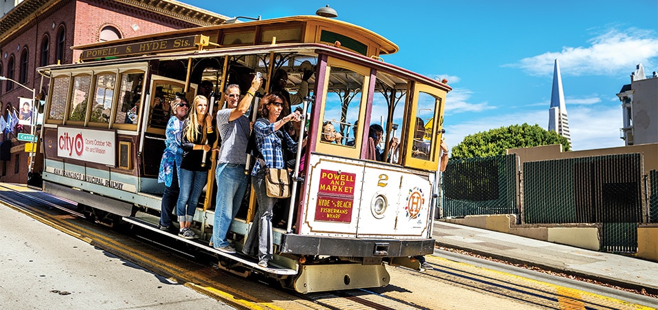 Passengers ride a San Francisco cable car.