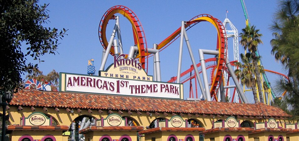 The ticket booths at the entrance of Knott's Berry Farm theme park, with rollercoasters in the background.