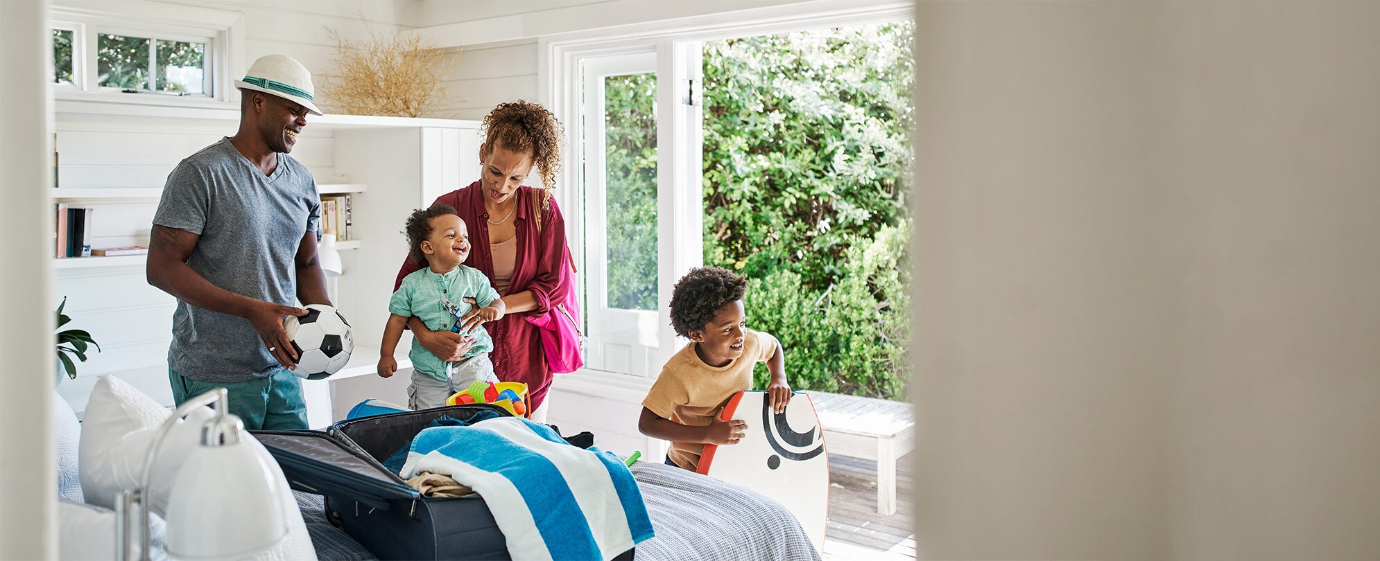 A mom, dad, and two young sons unpack their suitcase in a WorldMark resort suite.
