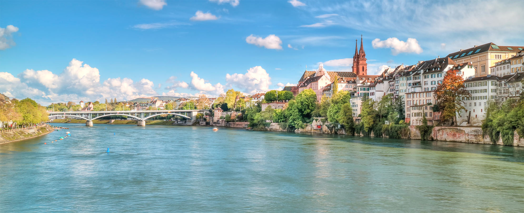 Panoramic view of the Rhine River in Switzerland with residential buildings in the background.