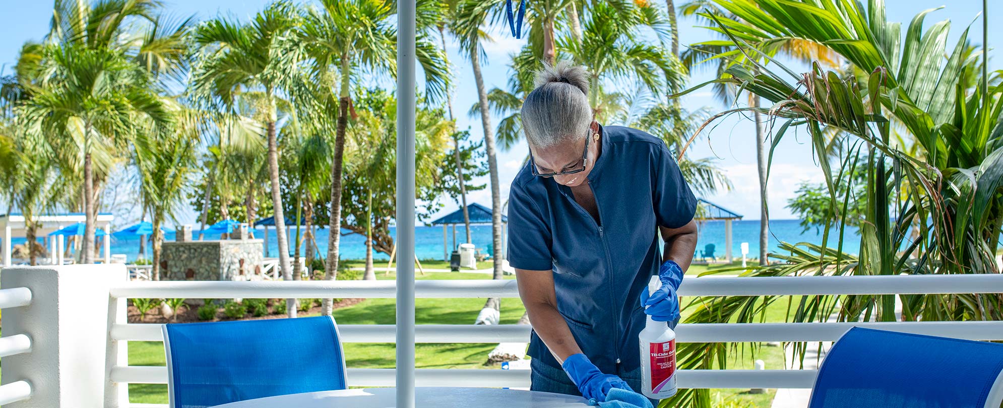 A WorldMark by Wyndham housekeeper, sanitizing the outdoor dining tables at the resort.