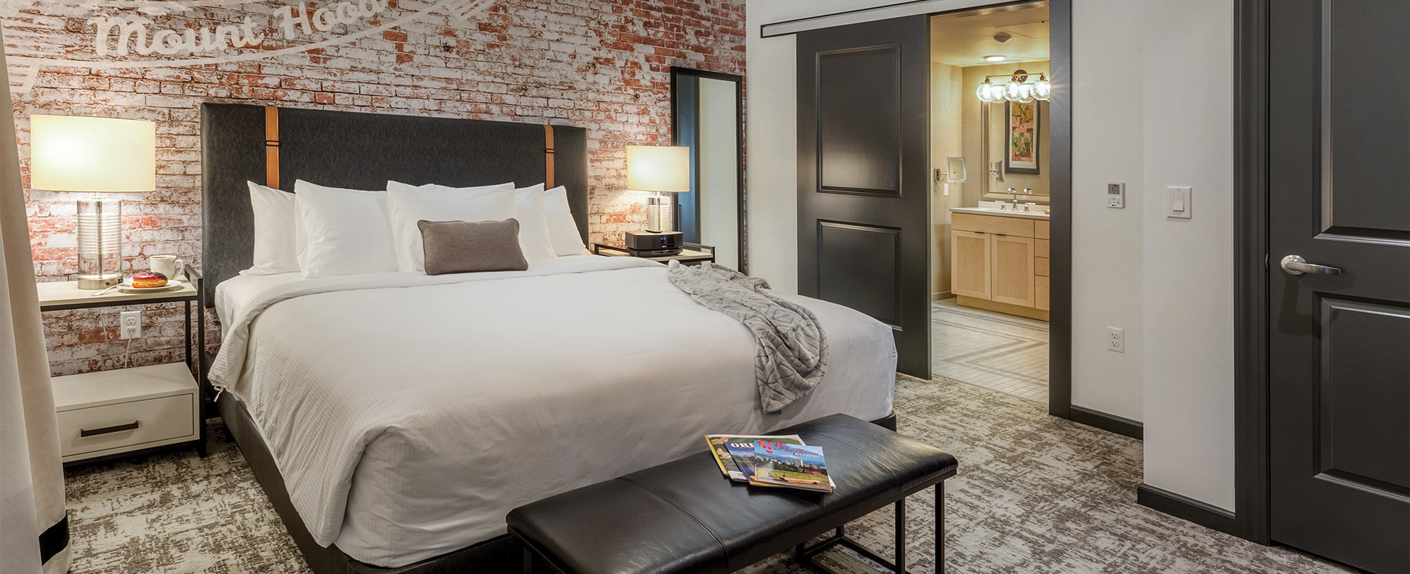 A suite bedroom with a bed and brick wall at WorldMark Portland Waterfront Park.