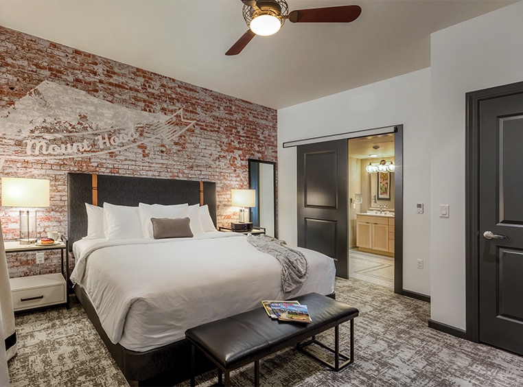 A suite bedroom with a bed and brick wall at WorldMark Portland Waterfront Park.