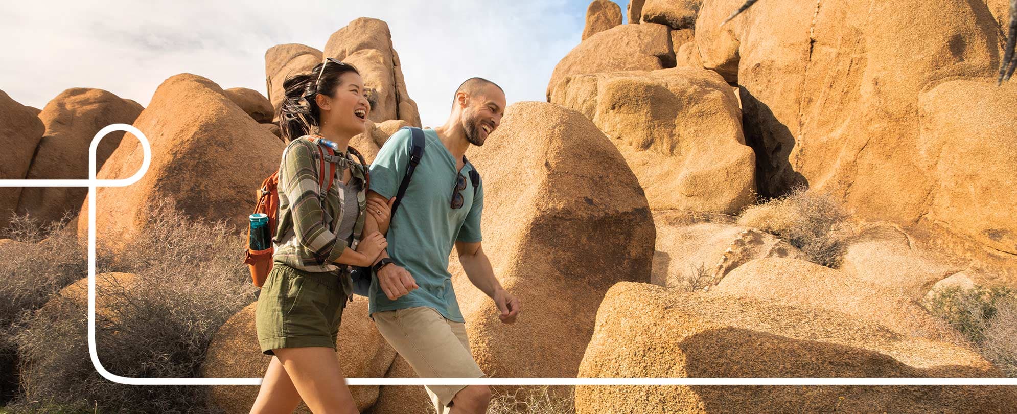 A smiling couple hikes along a rocky trail during their WorldMark by Wyndham vacation.
