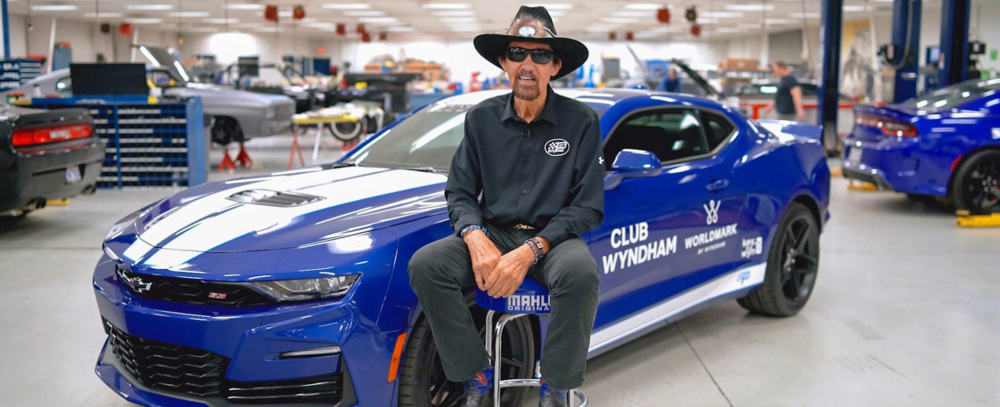 Richard Petty sits in front of a Club Wyndham and Worldmark by Wyndham branded Camaro.